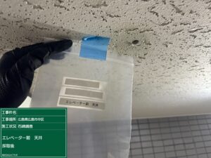 鉄骨造マンションのエレベーター前天井に小さな穴を開けて検体採取した後の状態